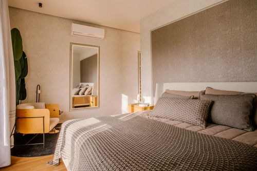 Free Warm and inviting modern bedroom with stylish decor and natural lighting. Stock Photo