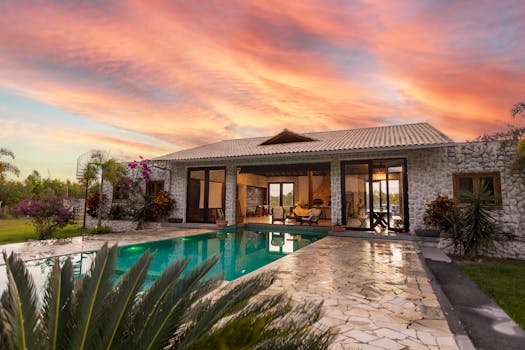 Beautiful stone villa with pool and vibrant sunset sky, perfect for luxury travel.