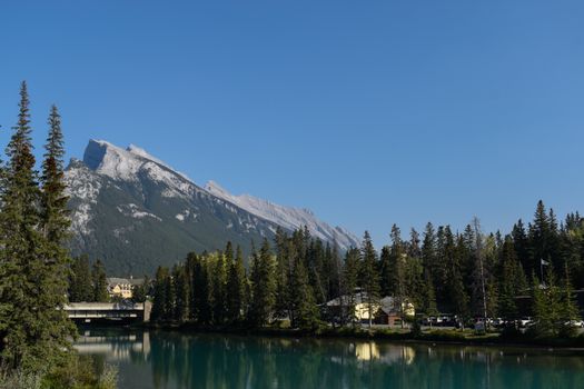 Beautiful landscape featuring Mount Rundle and Bow River in Banff, Alberta under clear skies.