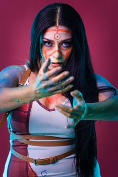 Vibrant portrait of a woman with colorful face paint and expressive pose.