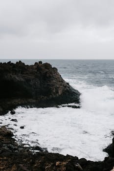 Waves crashing against the rugged coast in Lanzarote, Spain. Perfect for nature themes.