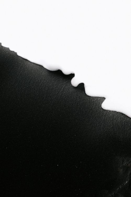 Free A striking abstract photo depicting the contrast between black sand and white foam. Stock Photo