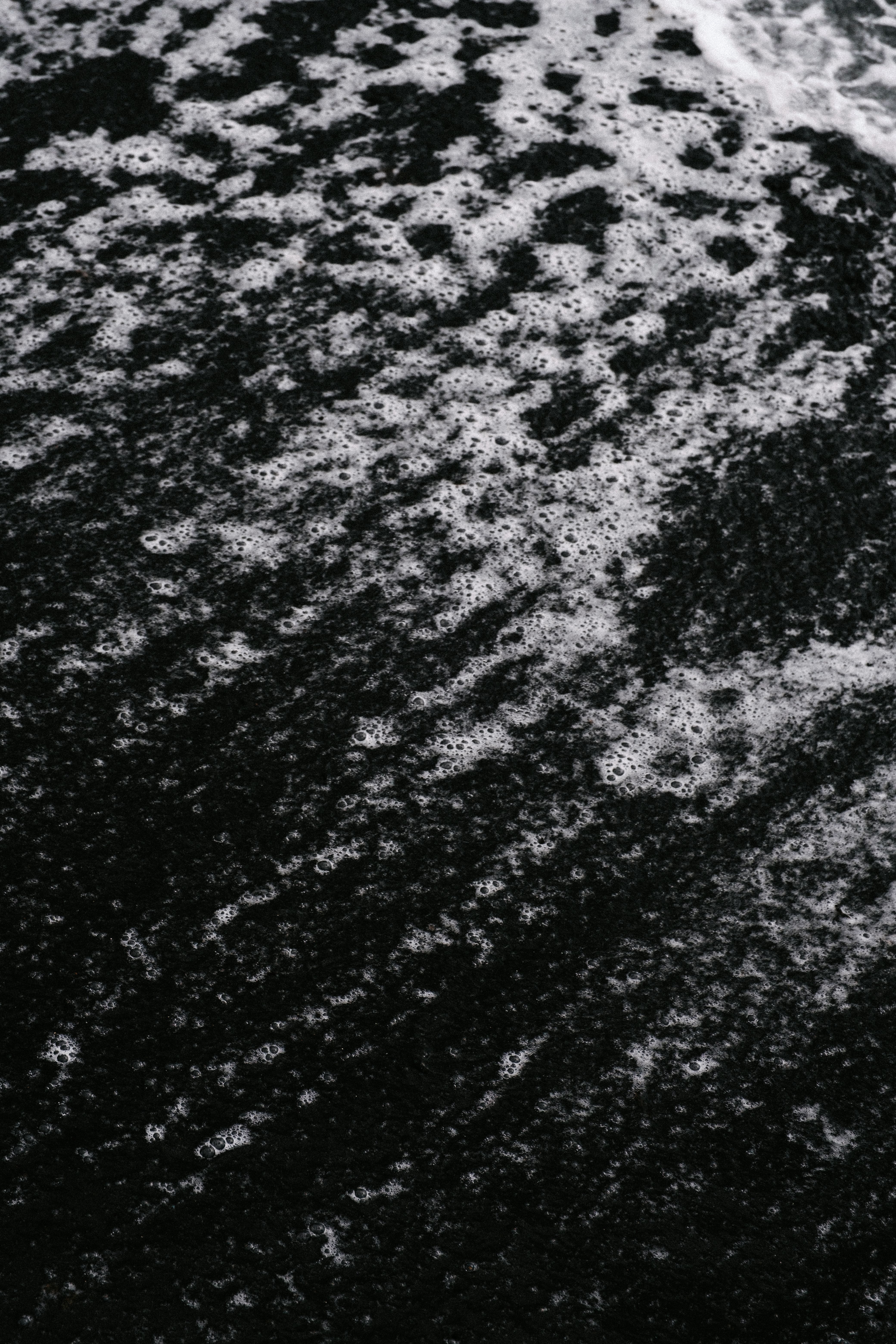 Captivating black sand beach with intricate wave patterns, showcasing natural beauty and texture.. pexels, captivating, black