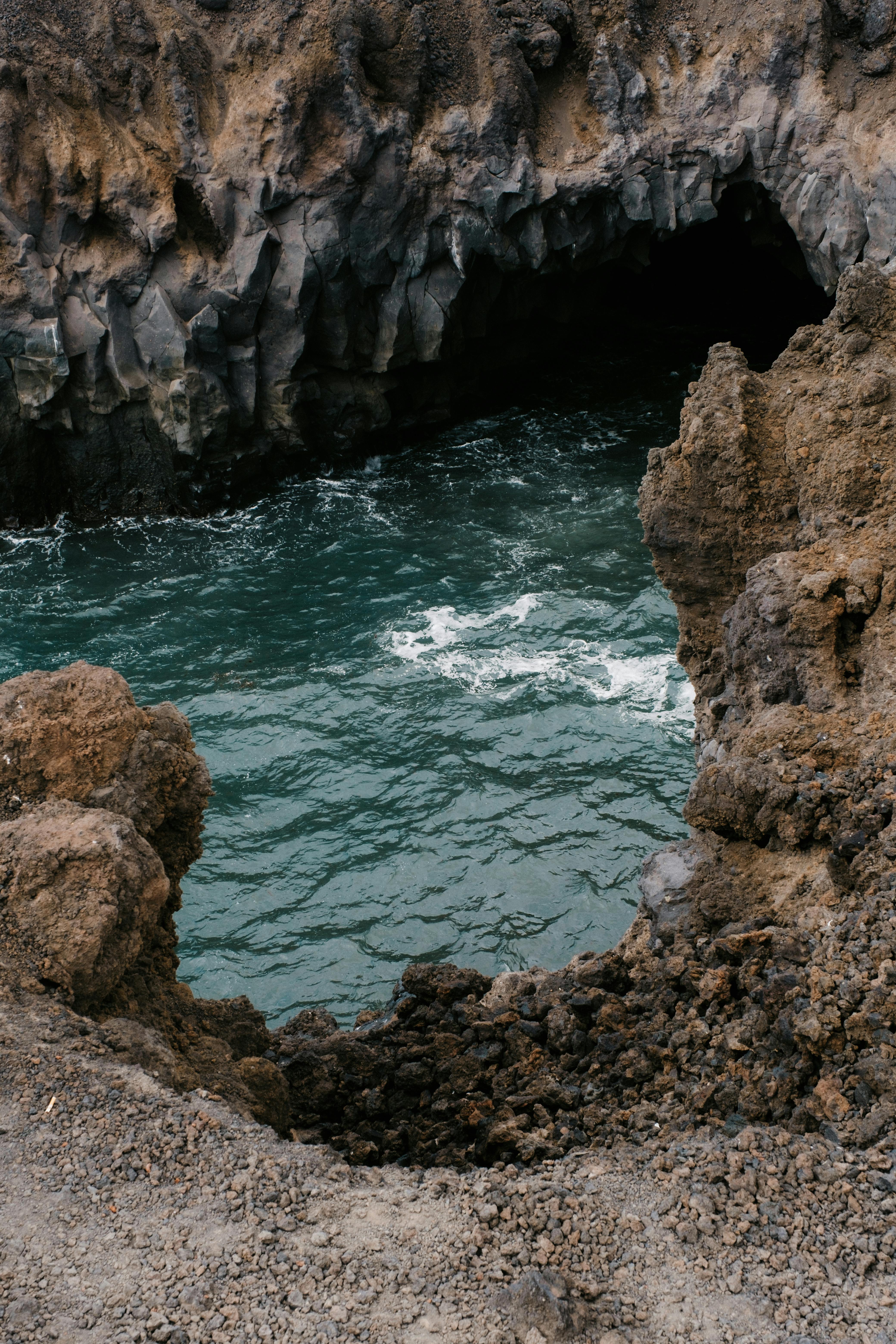 Waves crash against the volcanic cliffs of Lanzarote, showcasing a natural ocean cave.