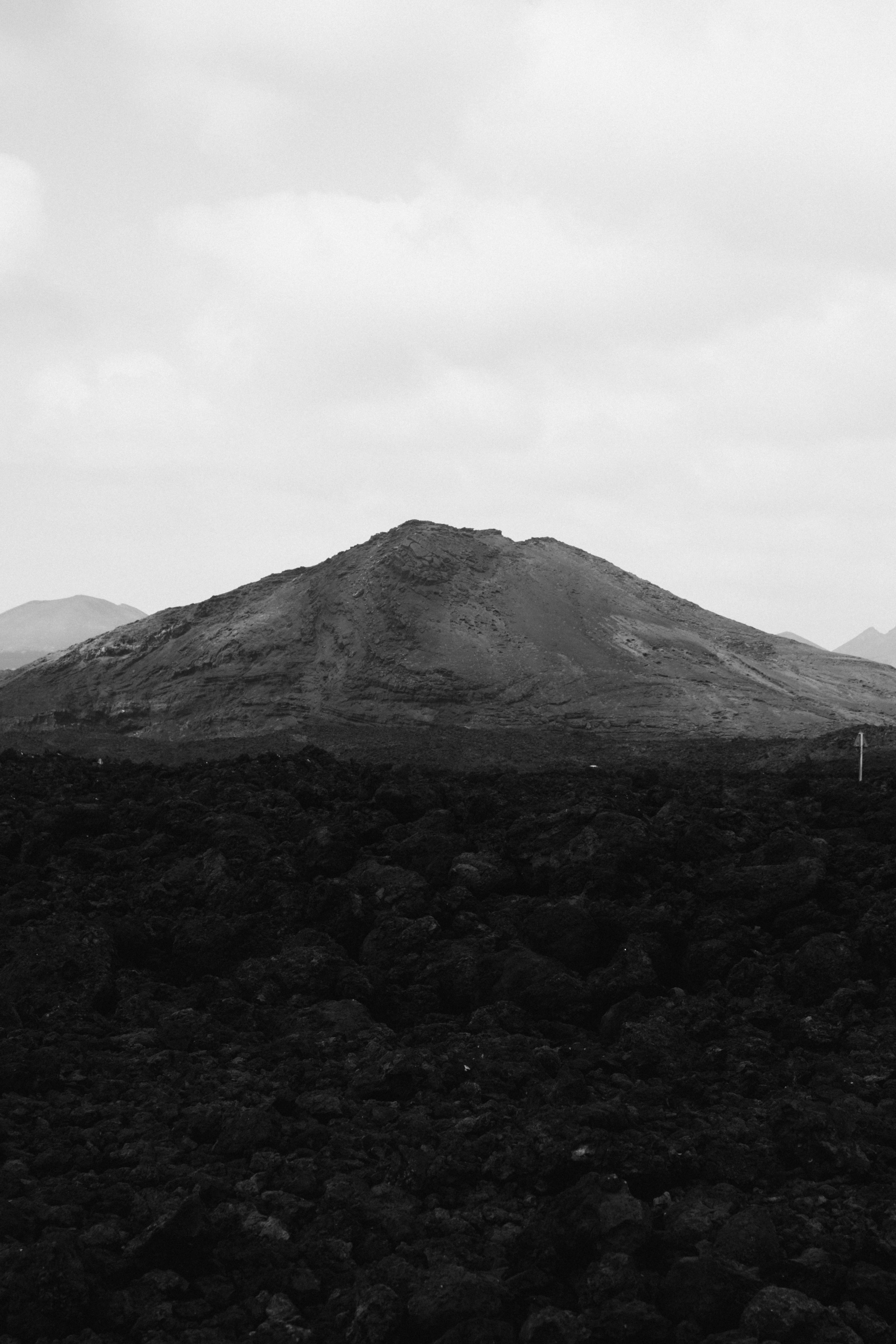 Black and white photo capturing a volcanic landscape in Lanzarote, Spain, showcasing rugged terrain and natural beauty.