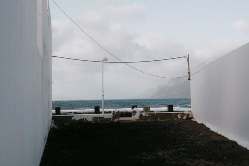 Free Tranquil ocean view framed by white walls and a cloudy sky. Stock Photo