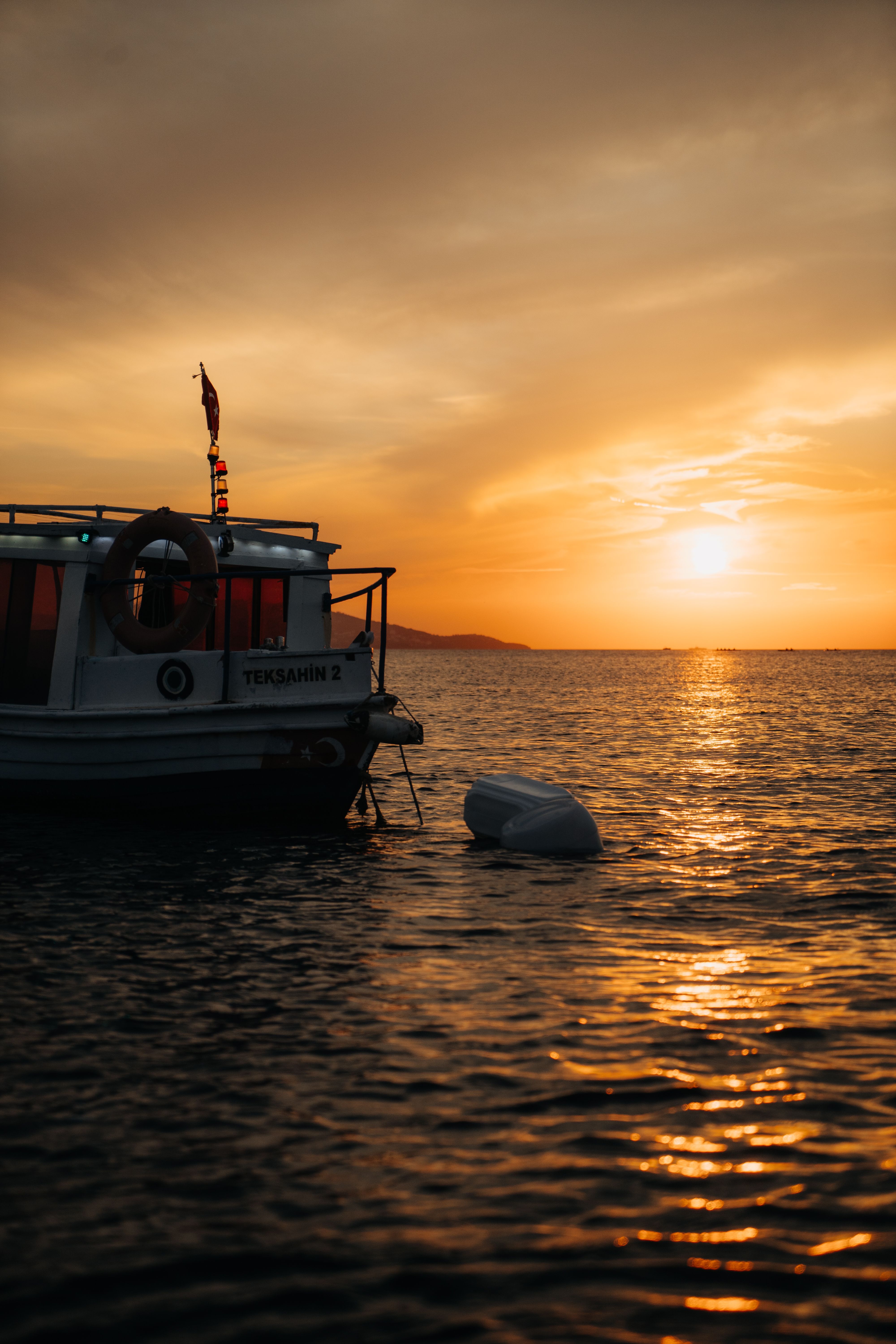 Sunset Over Calm Sea with Lone Boat · Free Stock Photo