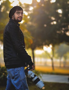 黄金时段，一位男摄影师手持相机站在户外