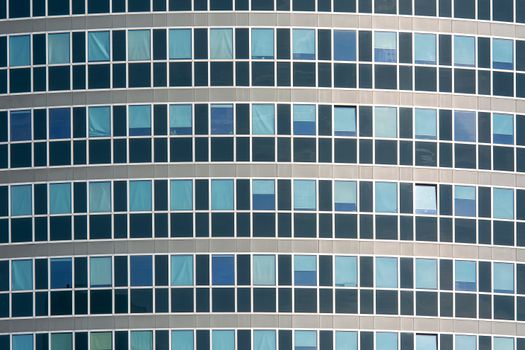 Close-up view of a modern office building facade with reflective glass windows.