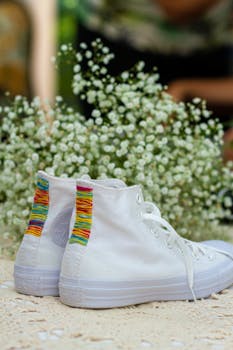 这款白色高帮运动鞋饰有彩虹细节和精致白花，适合户外运动
