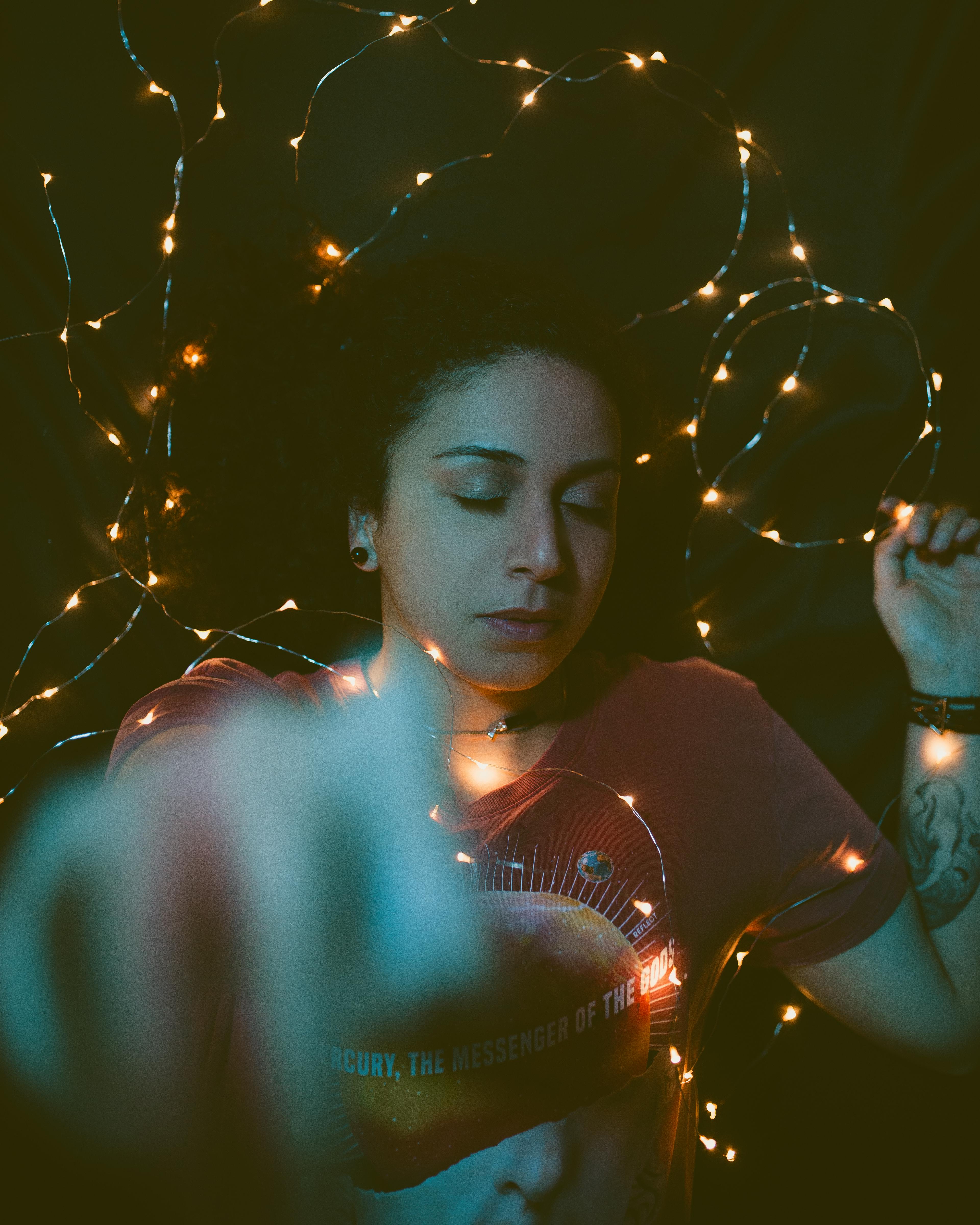 女人闭着眼睛，在柔和的灯光下休息，描绘出一片宁静