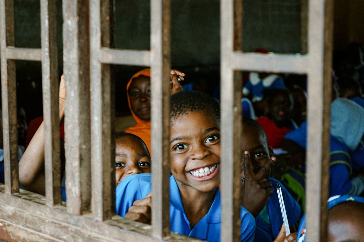 Children smiling through a classroom window