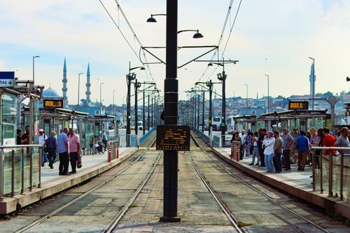 Free Tram station in Istanbul bustling with commuters, showcasing iconic minarets in the background. Stock Photo