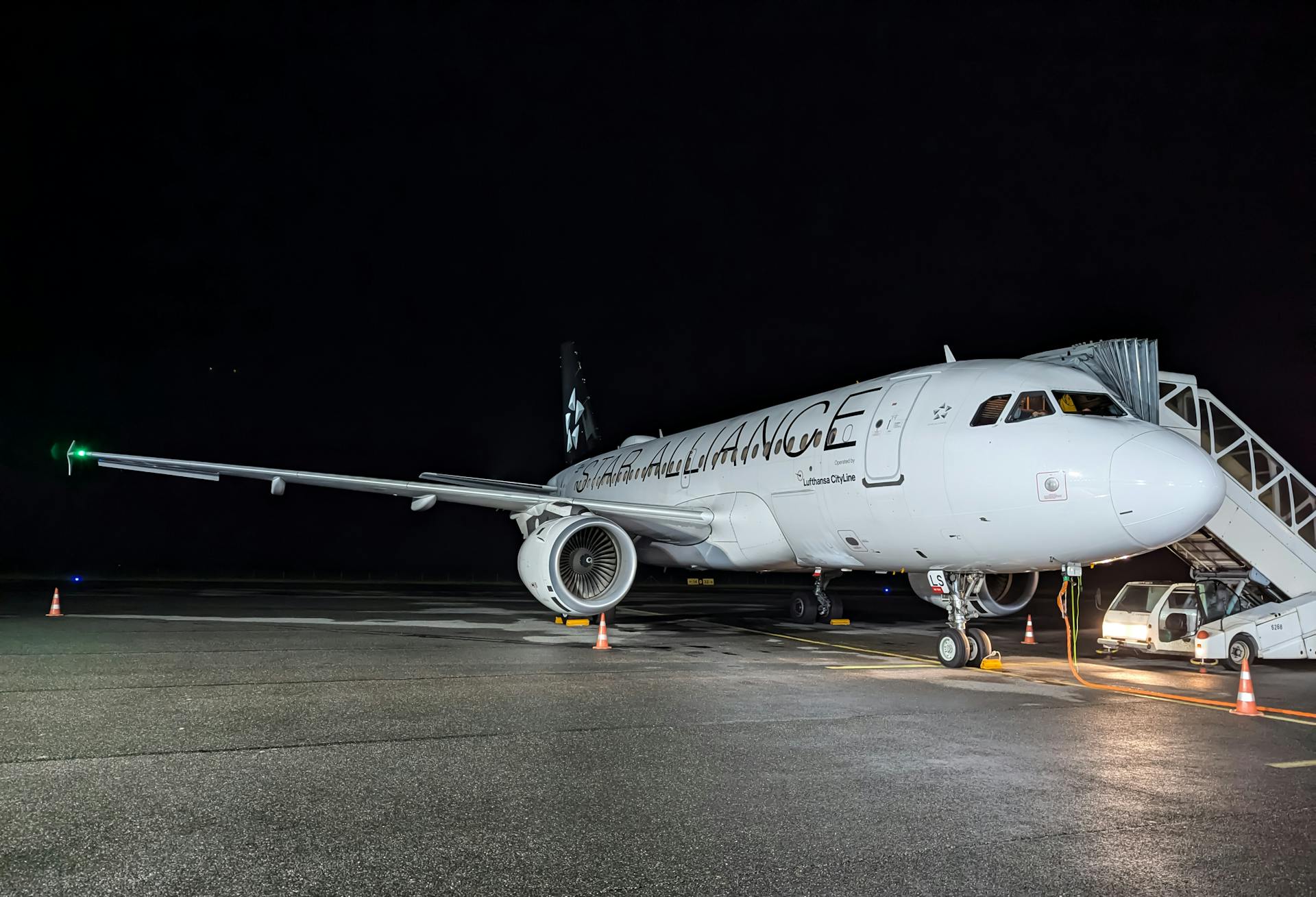 Airplane on Tarmac at Night with Boarding Stairs