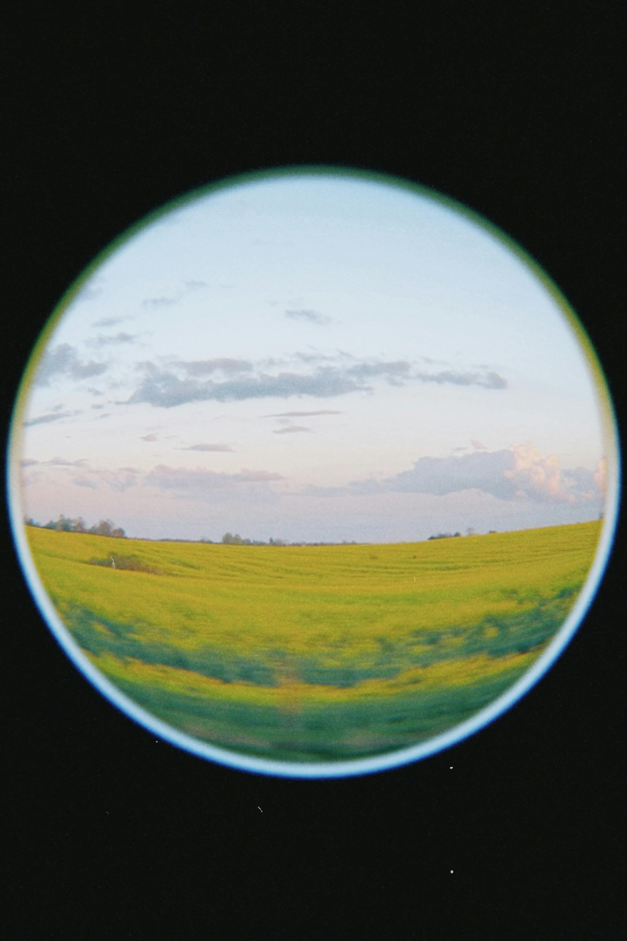 Fisheye lens captures vibrant green fields and blue sky in Ziesendorf, Germany.