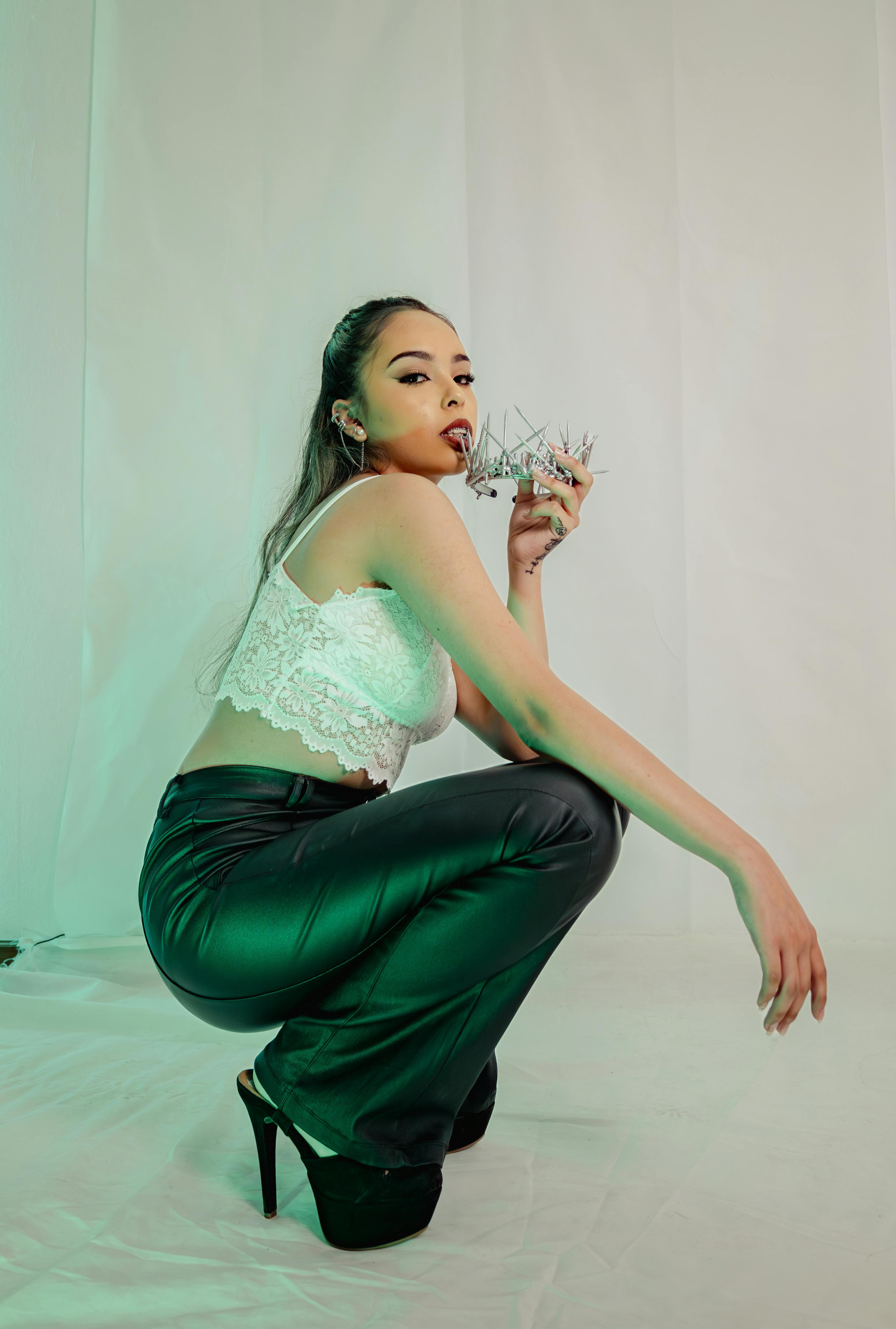 A fashionable woman poses in a studio with a modern style and sultry look.