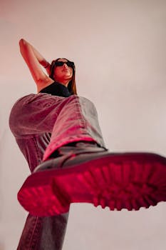 Stylish woman poses confidently in trendy attire. Unique low-angle shot enhances the look.