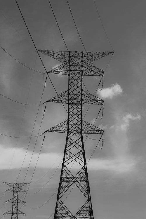 Free Black and white photo of towering power lines against a cloudy sky in San José Chiapa, México. Stock Photo