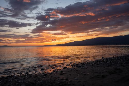 Free A breathtaking sunset over the tranquil sea and rocky shoreline at Balıkesir, Türkiye. Stock Photo