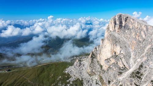 Free A breathtaking view of Alpine mountains and clouds under a clear blue sky. Stock Photo