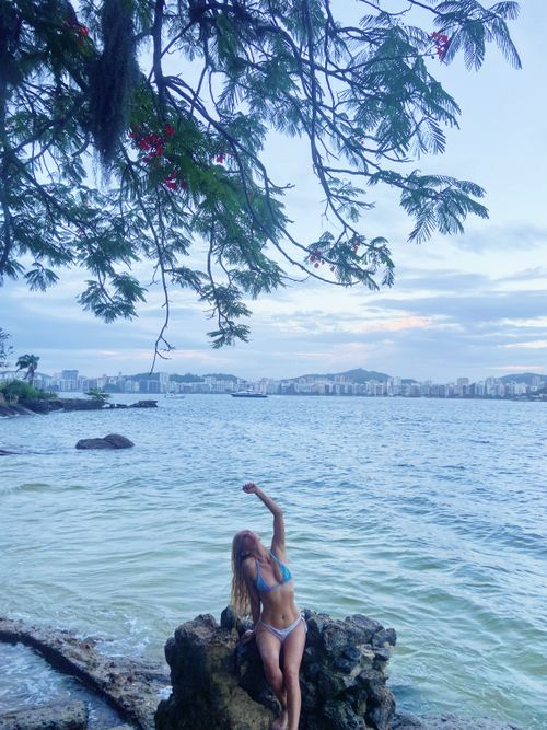 Free "Basking in Tropical Serenity: A Woman Stands by the Shore, Embracing the Peaceful Harmony of Nature, the Warm Breeze, and the Gentle Ocean Waves." Stock Photo