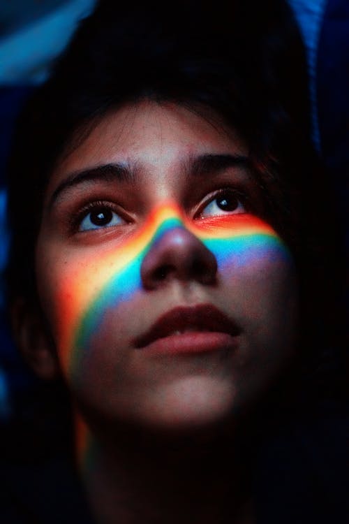 Free Woman With Rainbow Light Reflecting Her Face Stock Photo