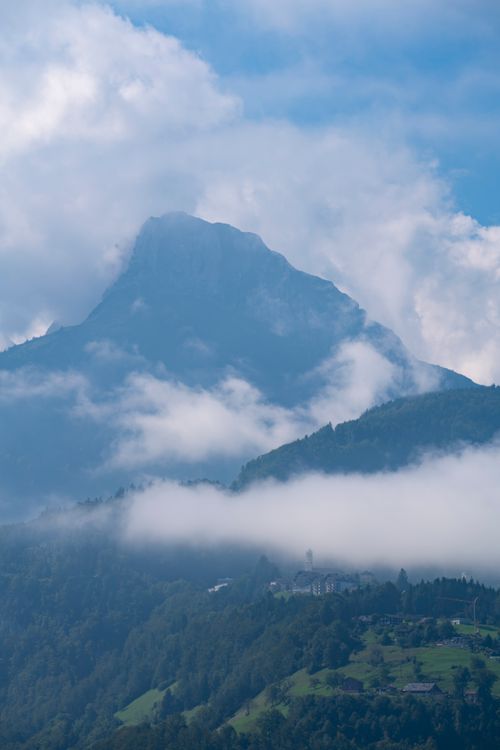 Free A serene view of a mountain peak surrounded by clouds, showcasing natural beauty. Stock Photo