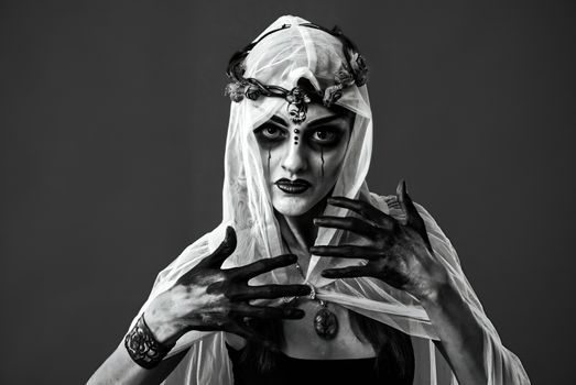 Dramatic black and white photo of a gothic woman with veil and dark makeup.