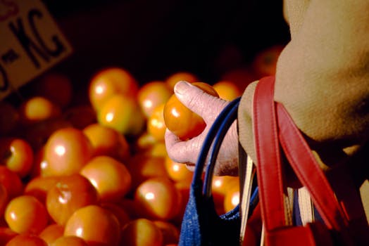 Close-up of a hand picking a tomato at a Melbourne market.