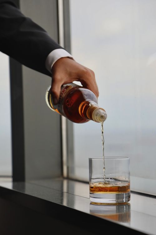 Free Close-up view of whiskey being poured into a glass by a window in Istanbul. Stock Photo
