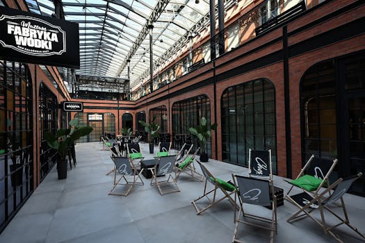 Interior of the Vodka Factory Museum Kraków with seating and glass ceiling.