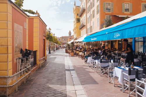 Free Cozy outdoor cafe seating in Nice, France. Perfect for a summer day out. Stock Photo