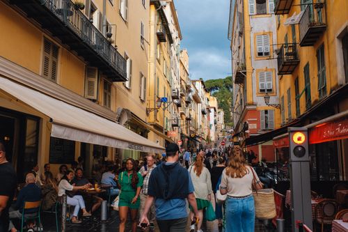 Free Vibrant street scene with busy cafes and strolling pedestrians in a European city. Stock Photo