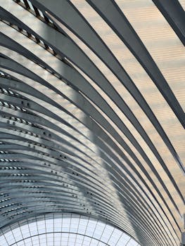 A modern architectural ceiling featuring elegant arched patterns in a spacious indoor setting.