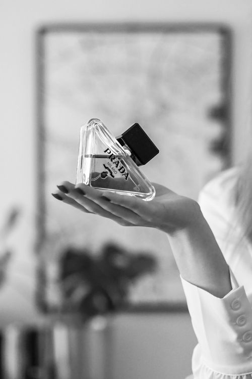 Free Chic black and white image featuring a Prada perfume bottle elegantly held on an open hand. Stock Photo