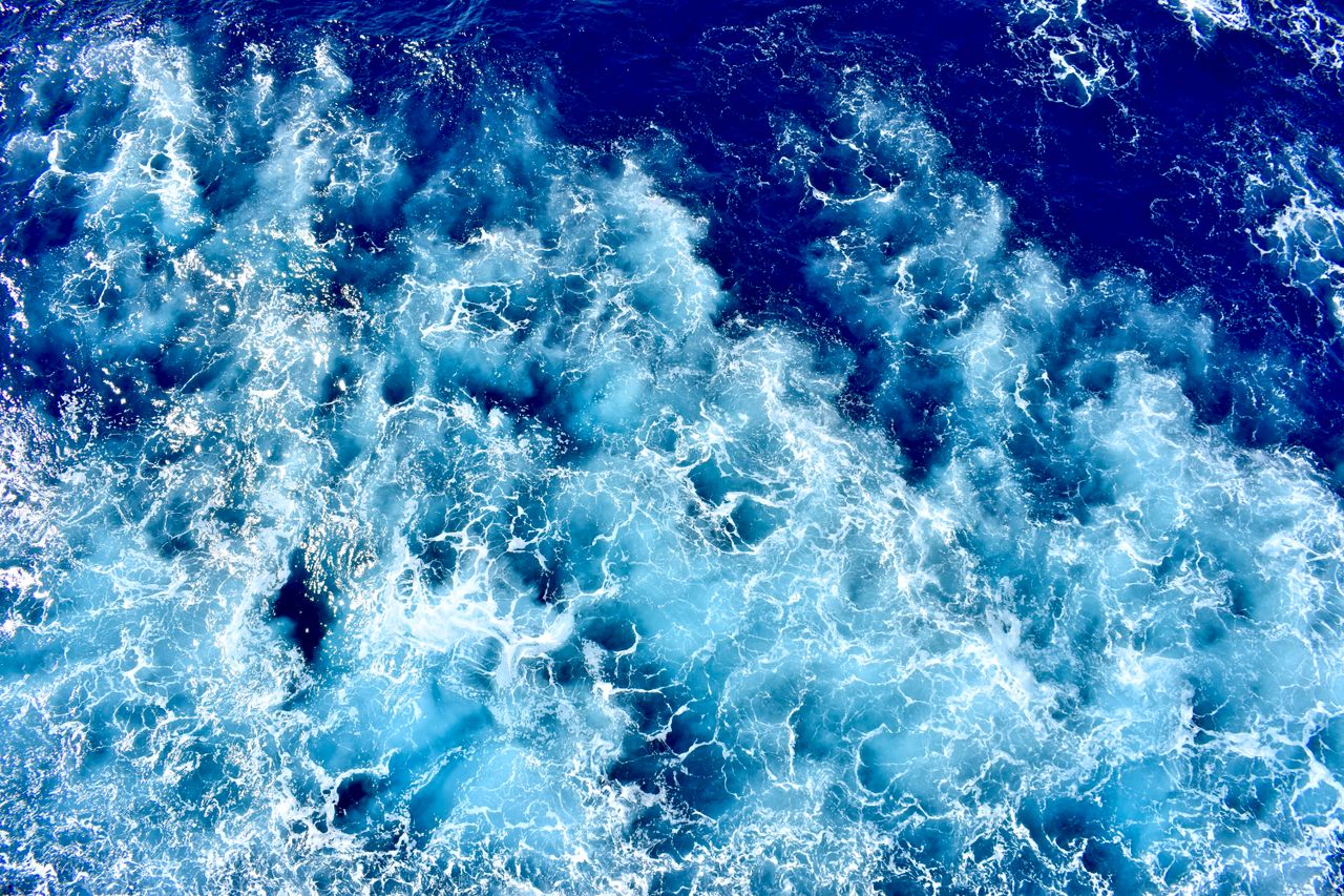 dynamic aerial perspective of vibrant blue waves crashing in the ocean
