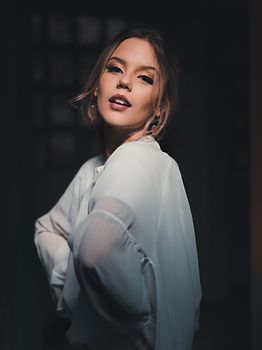 在柔和的灯光下，优雅的女人摆出姿势，展现美丽与风格