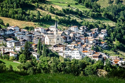 Free Picturesque view of an Alpine village nestled among lush green hills. Stock Photo