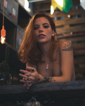 一位时尚女士在室内摆姿势，展示她独特的纹身风格和配饰