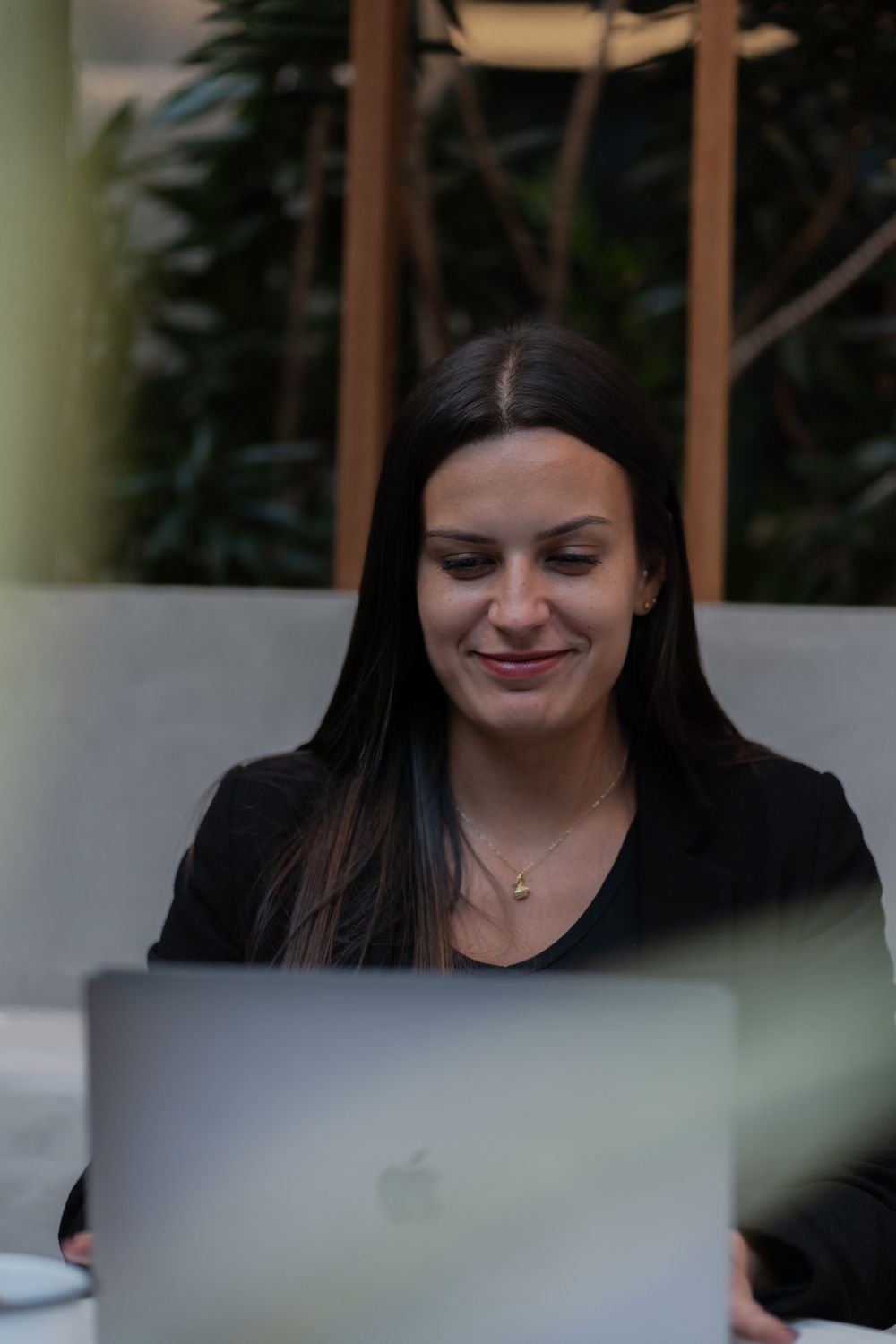 Junge Frau lächelt am Laptop
