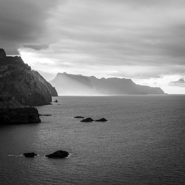 Black and white rugged coastline under dramatic sky — photo by Alexandre Moreira on Pexels