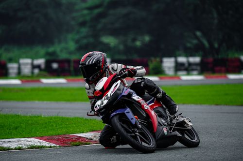 Free Motorcycle racer in protective gear leans during a turn on a race track. Stock Photo