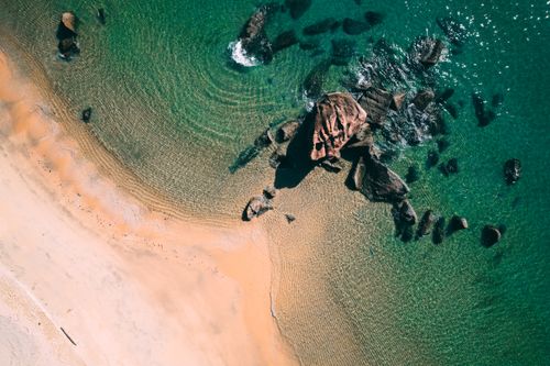 Free Stunning aerial view of a beach with rocks and clear turquoise water in Malaysia. Stock Photo