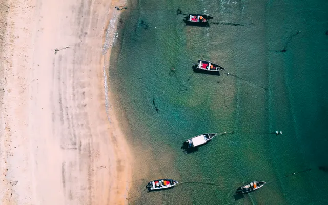 Aerial view of boats beside a tropical beach