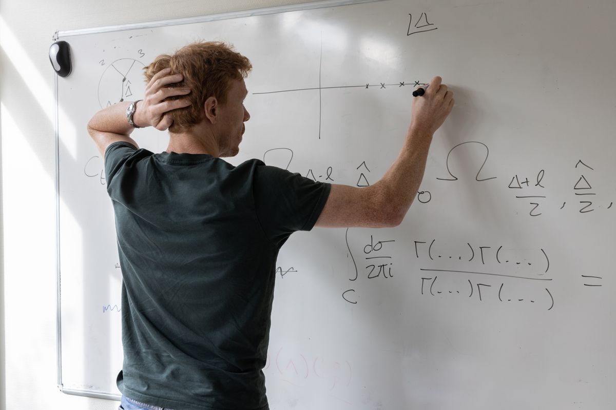 Person working through math equations on a whiteboard
