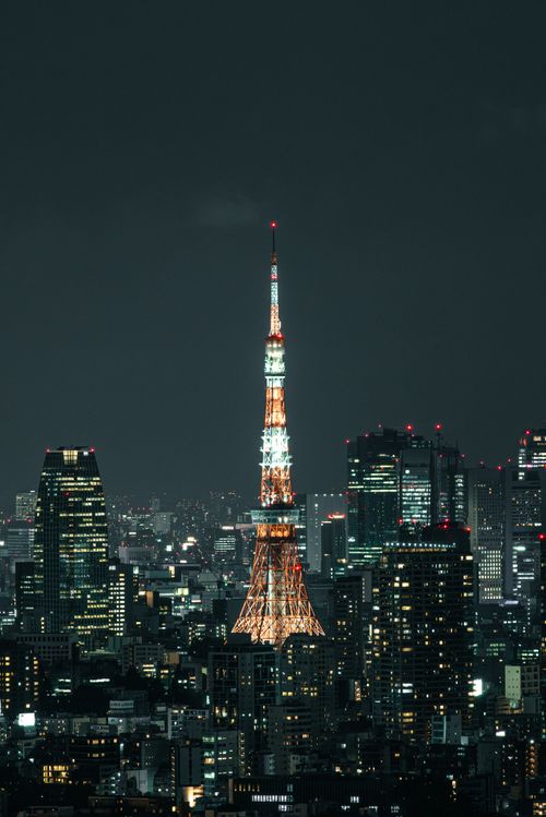 Free Stunning view of Tokyo Tower illuminated amidst the city skyline under a dark sky. Stock Photo