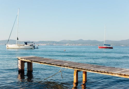 Free Tranquil view of the sea and sailboats from a wooden pier in Zadar, Croatia. Stock Photo