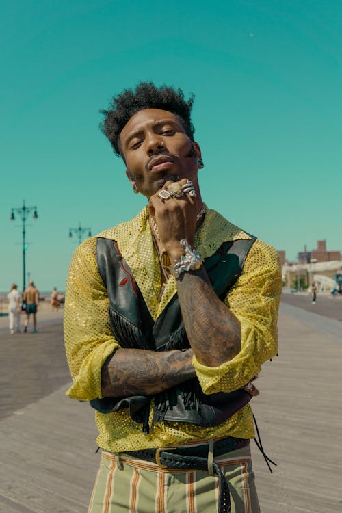 Man in Yellow Button-up Shirt, Blakc Leather Vest, and Striped Bottoms Outfit