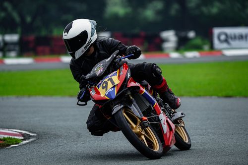 Free Dynamic shot of a motorcycle racer leaning into a curve on a wet race track. Stock Photo