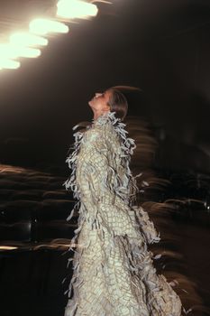 Dynamic motion capture of a fashion model in an avant-garde outfit indoors.
